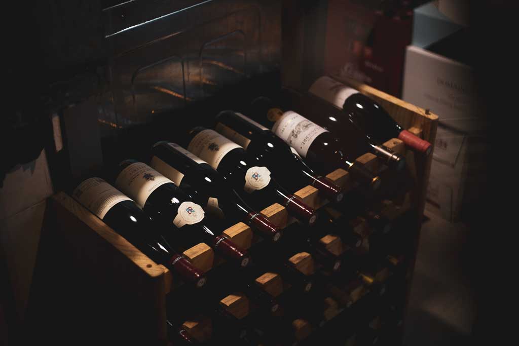 Bouteilles de vin sur un porte-bouteilles en bois.
